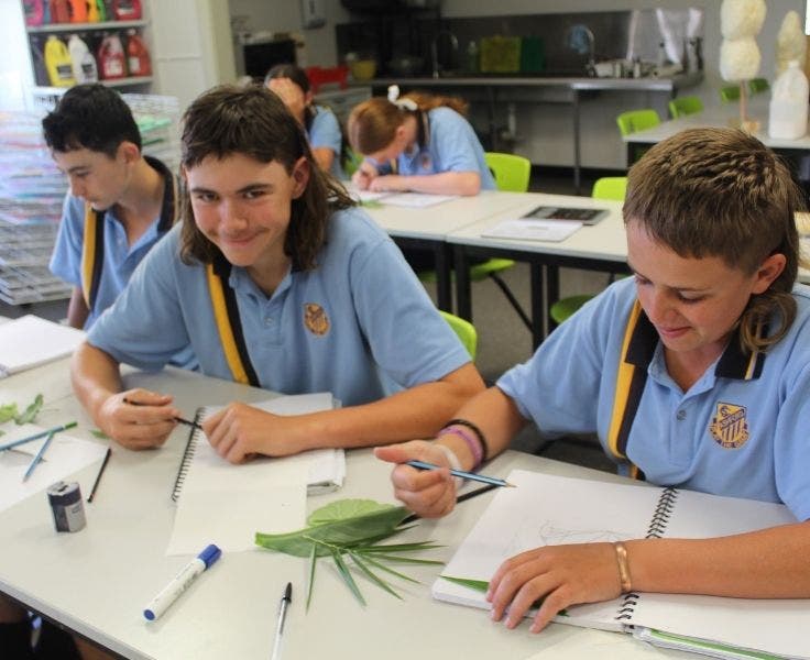 Two secondary students drawing images of leaves in the art classroom