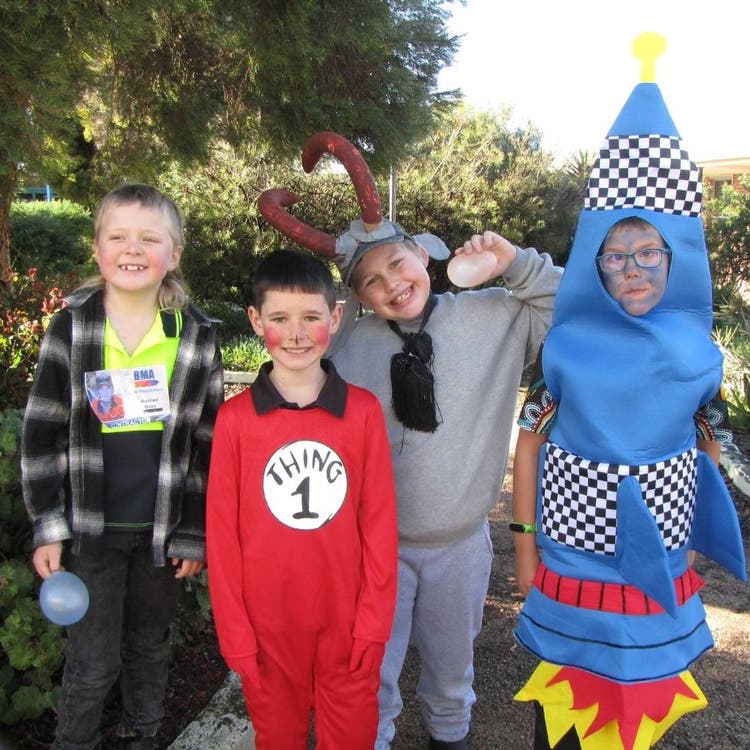 Four students standing in the school garden dressed up in bookweek costumes