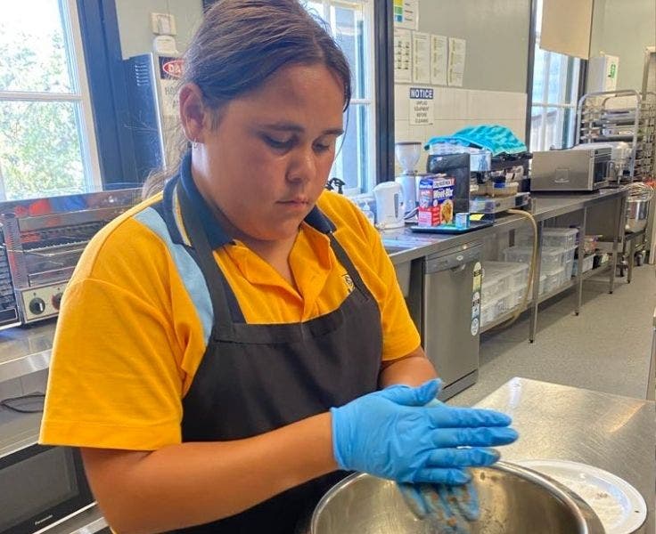 One student rolling chocolate balls in the commercial kitchen facility