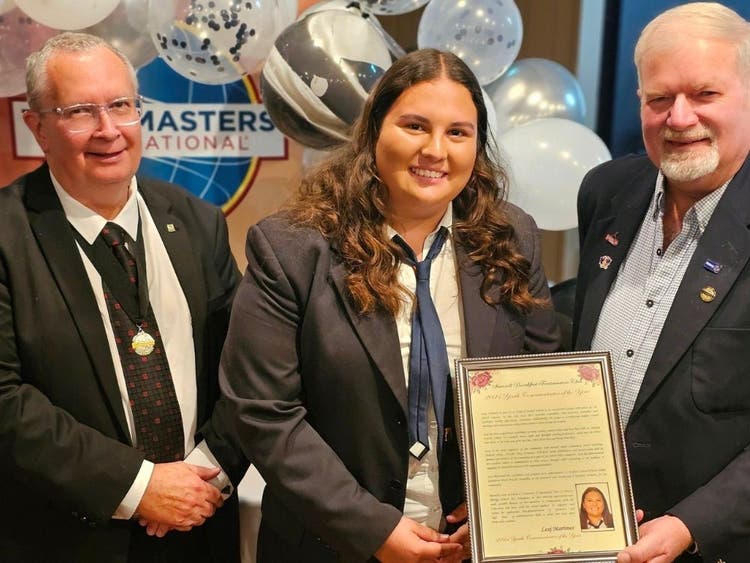 A student receiving the communicator of the year award from Inverell Toastmasters committee members