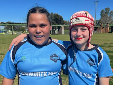 Two students wearing regional football shirts
